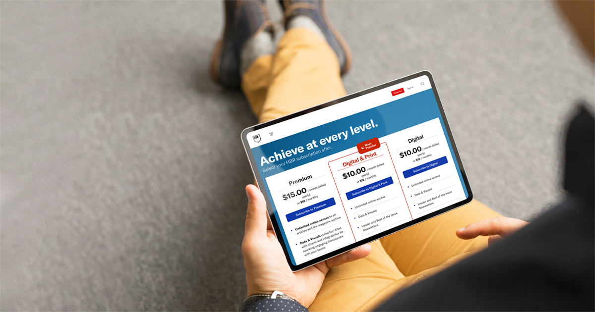 A person holding a tablet displaying the HBR subscriptions webpage.
