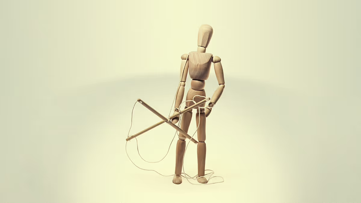 A wooden figure holding it’s marionette strings.