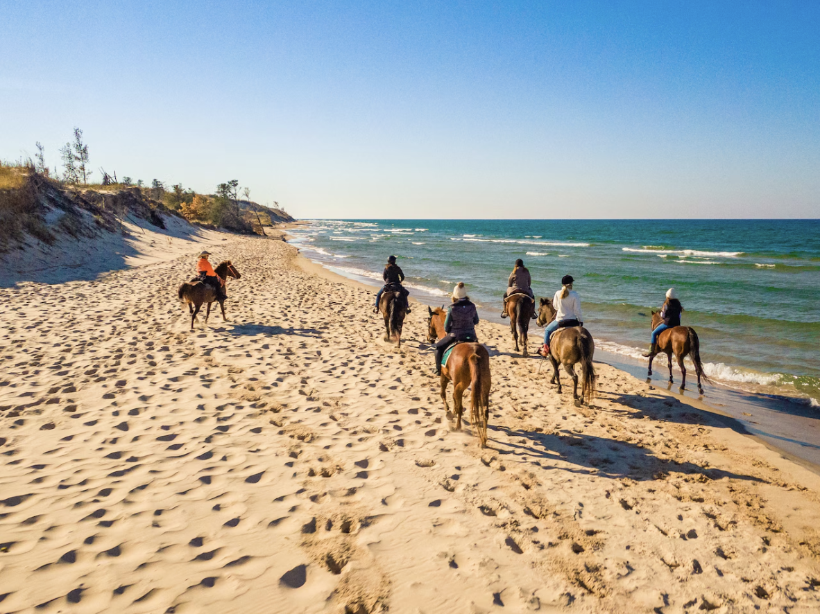 People ride horseback on the beach 
