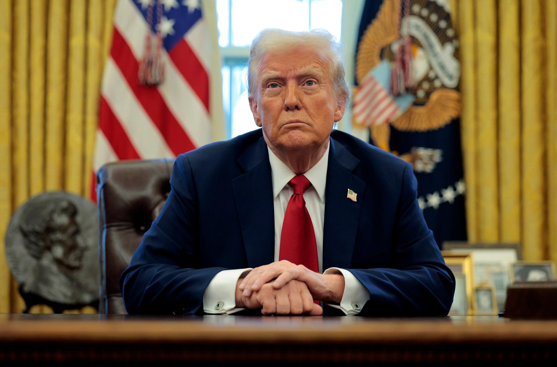 Trump sits behind desk in Oval Office