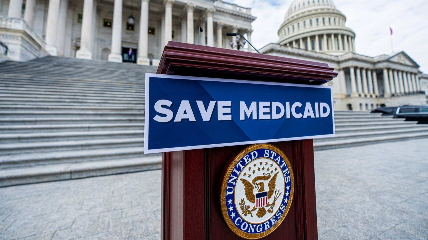Podium with Save Medicaid sign