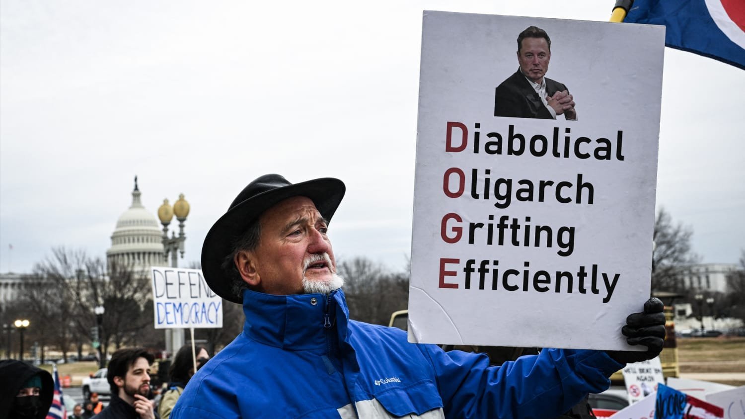 Man with DOGE protest sign