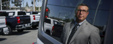 Attorney Michael Rogers stands at a Kia dealership in El Cajon. 