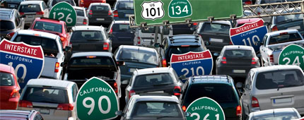 Photo illustration of several cars in traffic with highway signs among them. Photo illustration of several cars in traffic with highway signs among them.