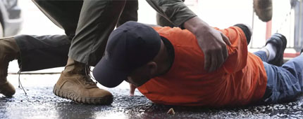 A man is detained by immigration agents at a car wash. A man is detained by immigration agents at a car wash.