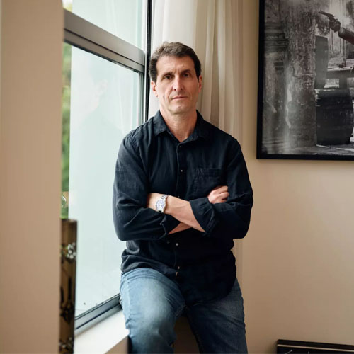 A man crosses his arms in his office.