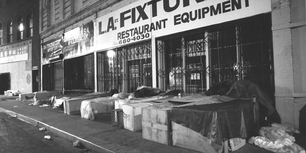 Homeless people sleep in boxes along storefronts in Los Angeles in 1987.