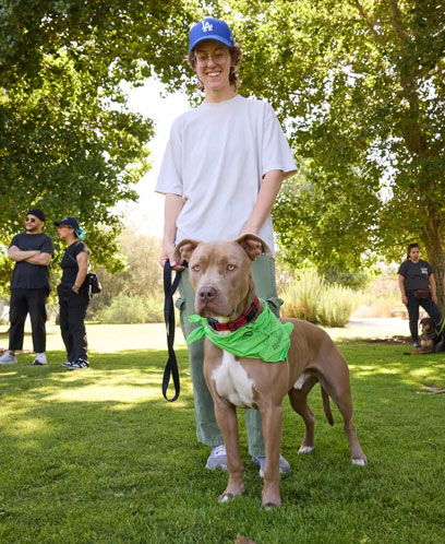 A woman holds a dog's leash.