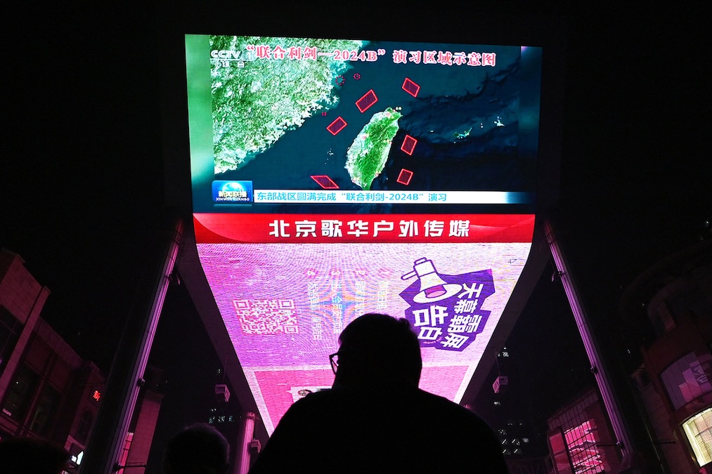 A man in Beijing watches a news program about Chinese military drills surrounding Taiwan. (Greg Baker/AFP/Getty Images)