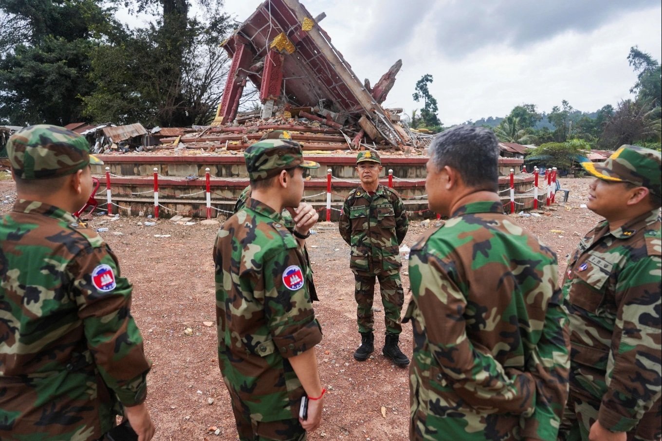 Military personnel stand near a destroyed monument at the closed An Ses border checkpoint, also known as Chong Arn Ma in Thai, in Cambodia on August 4. 
