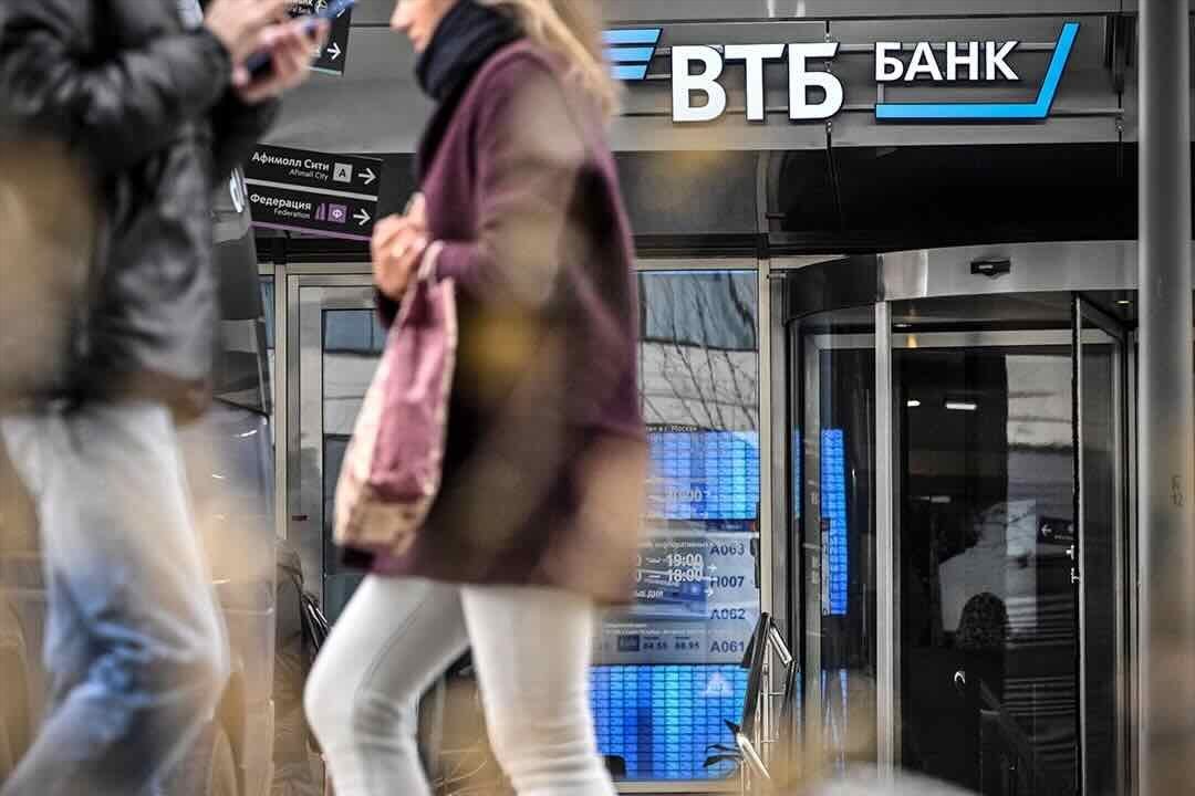 People walk past a branch of Russian VTB bank in Moscow on April 5, 2023.
