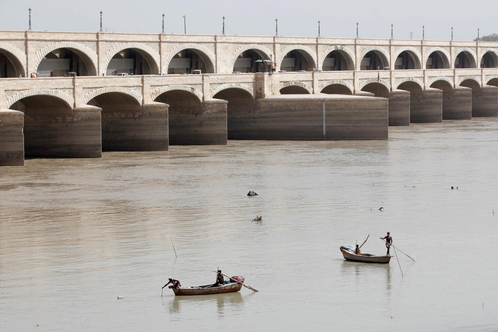 Fishermen row their boats as they catch fish on the Indus River, in Sukkur, Pakistan, on March 19, 2017. 