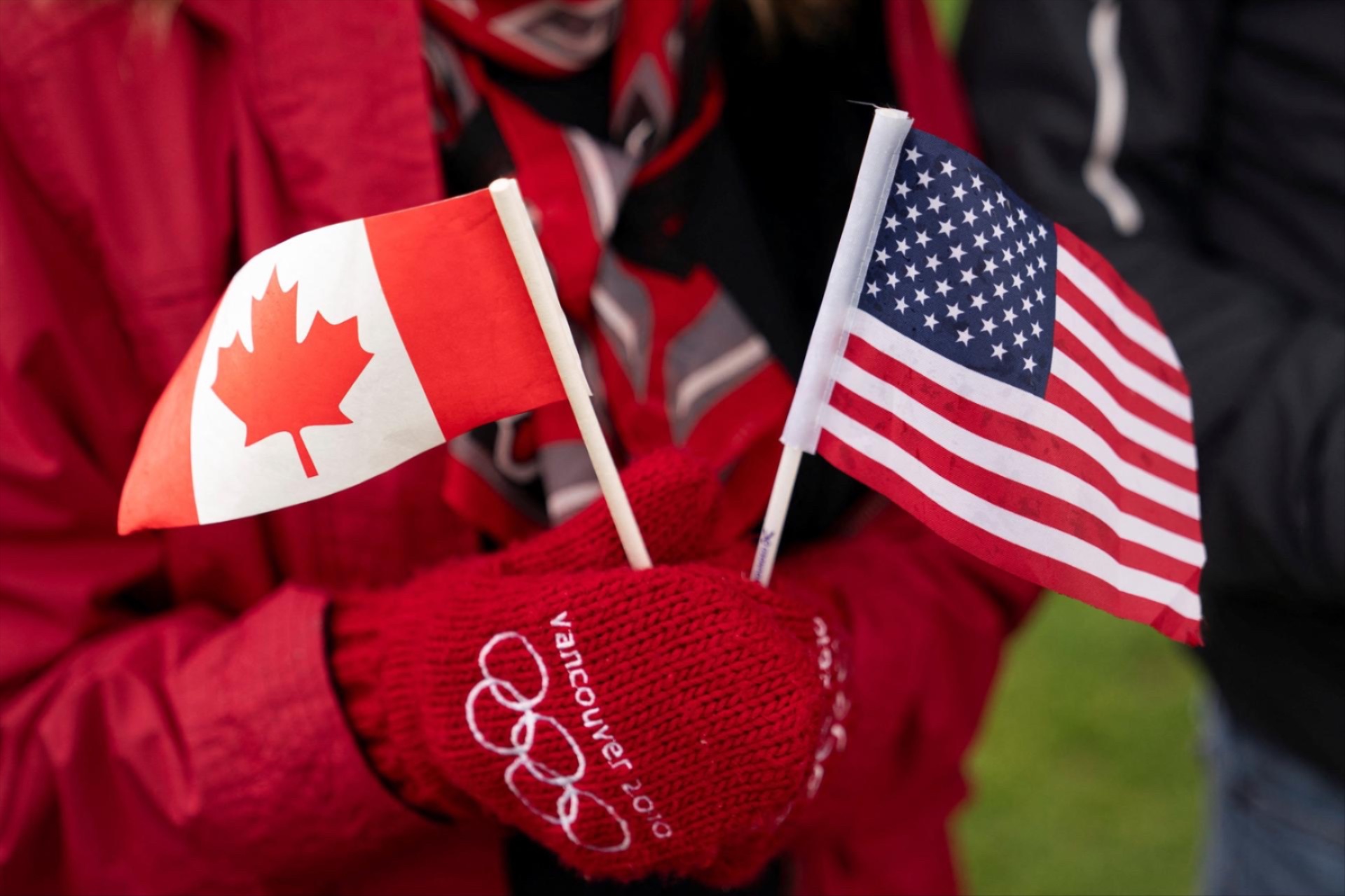 U.S. citizen Karen Dempsey holds small flags during a ''Peace, Love, and a Handshake'' solidarity rally at the Peace Arch Border Crossing at the Canada-U.S. border in Blaine, Washington, U.S. April 6, 2025.