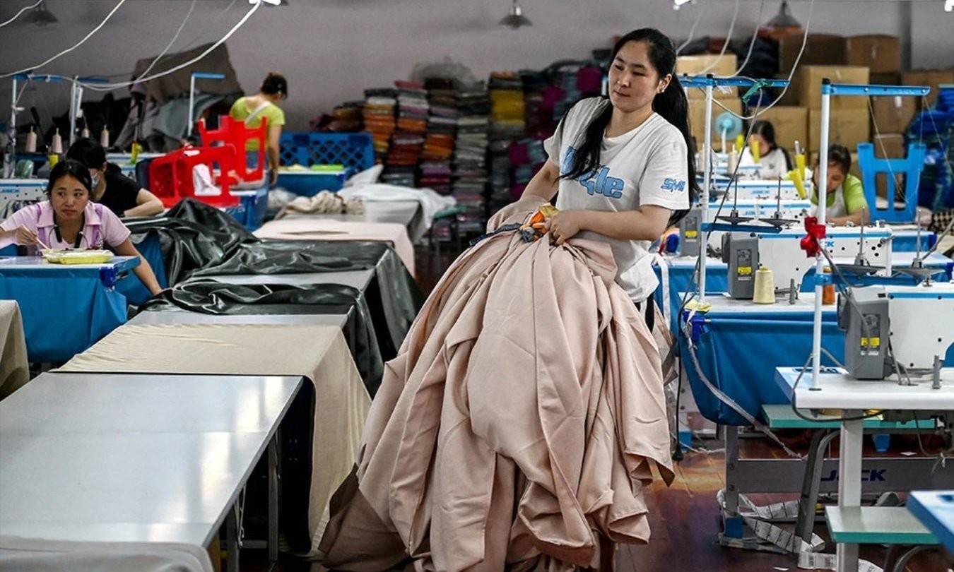 A worker carries curtains at a textile company in Shaoxing, China, May 9, 2025. 