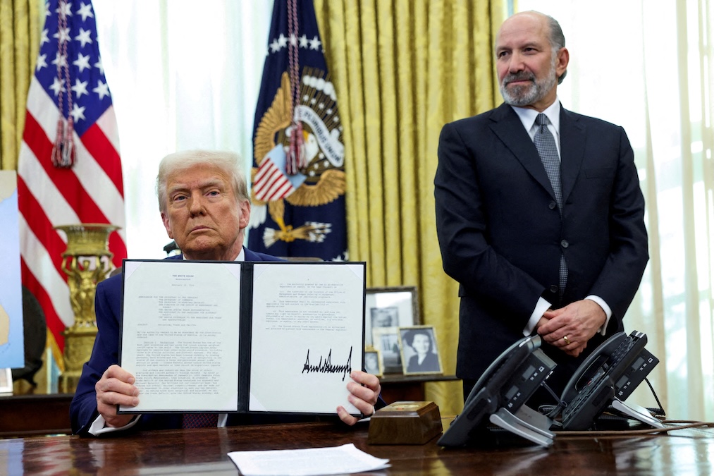 U.S. President Donald Trump holds an executive order about tariffs increase, flanked by U.S. Commerce Secretary Howard Lutnick, in the Oval Office of the White House in Washington, D.C., U.S., February 13, 2025. (Kevin Lamarque/Reuters)