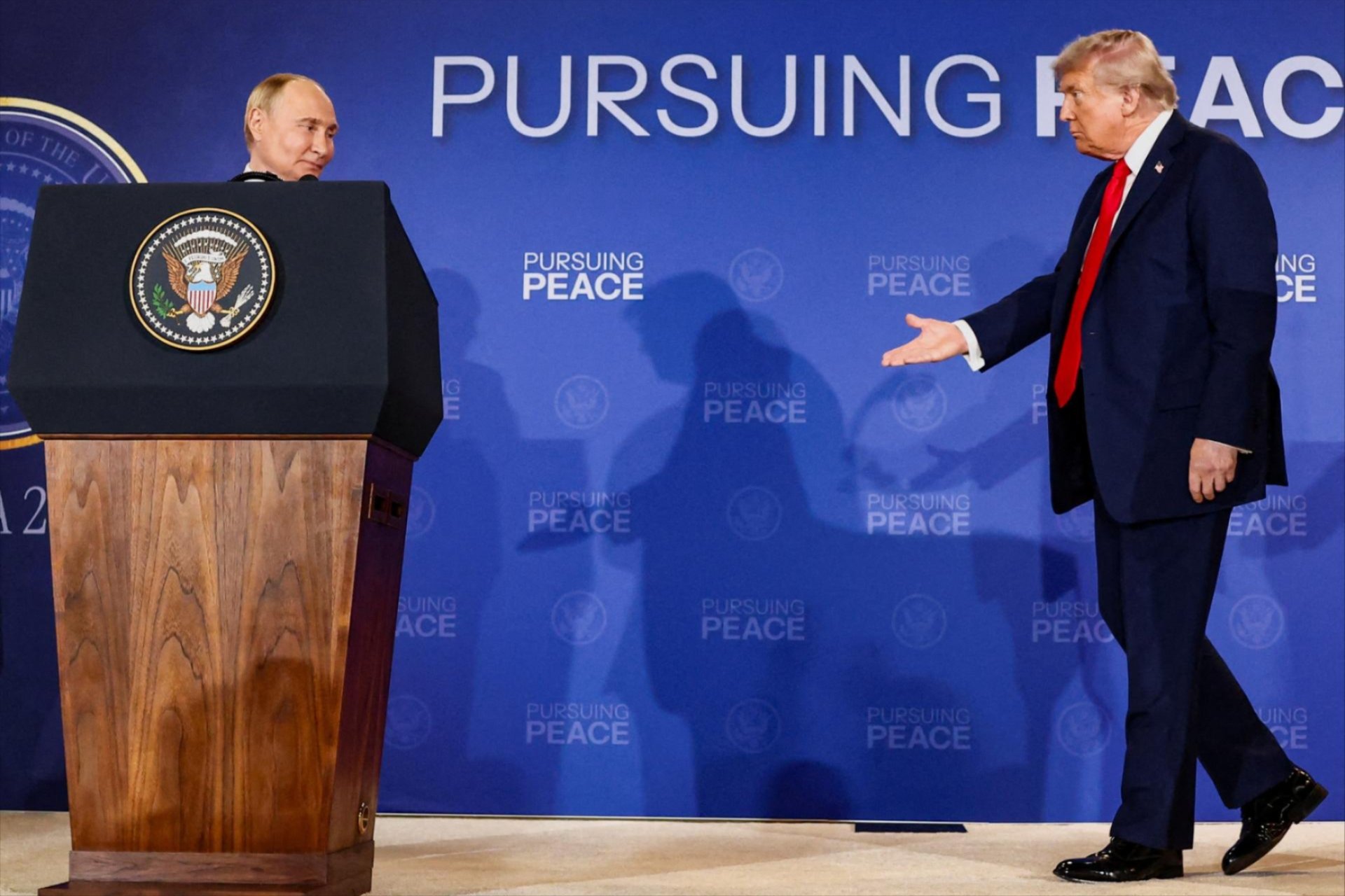 U.S. President Donald Trump walks towards Russian President Vladimir Putin during a press conference following their meeting to negotiate an end to the war in Ukraine, at Joint Base Elmendorf-Richardson, in Anchorage, Alaska, U.S., August 15, 2025. 
