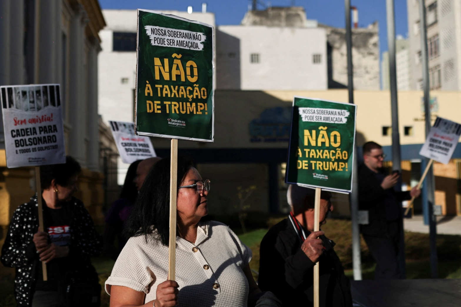 A demonstrator holds a sign reading in Portuguese 