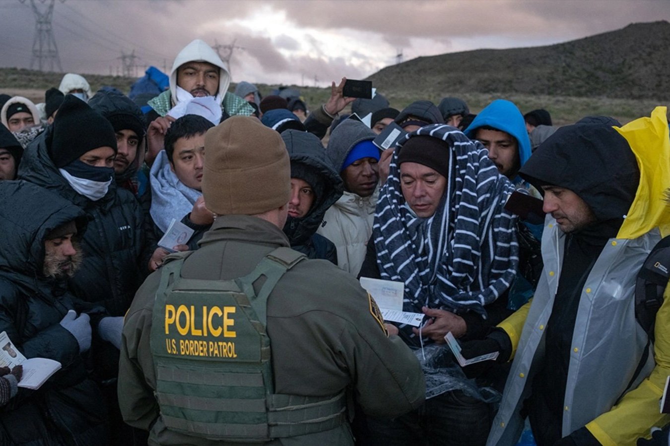 A Border Patrol agent processes asylum seekers at an improvised camp in California near the U.S.-Mexico border.