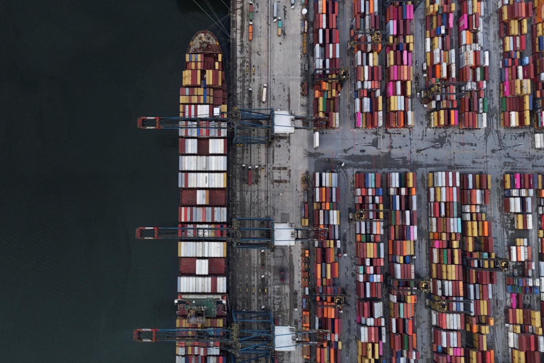 An American flag flutters over a ship and shipping containers at the Port of Los Angeles, in San Pedro California, U.S., May 13, 2025. REUTERS/Mike Blake