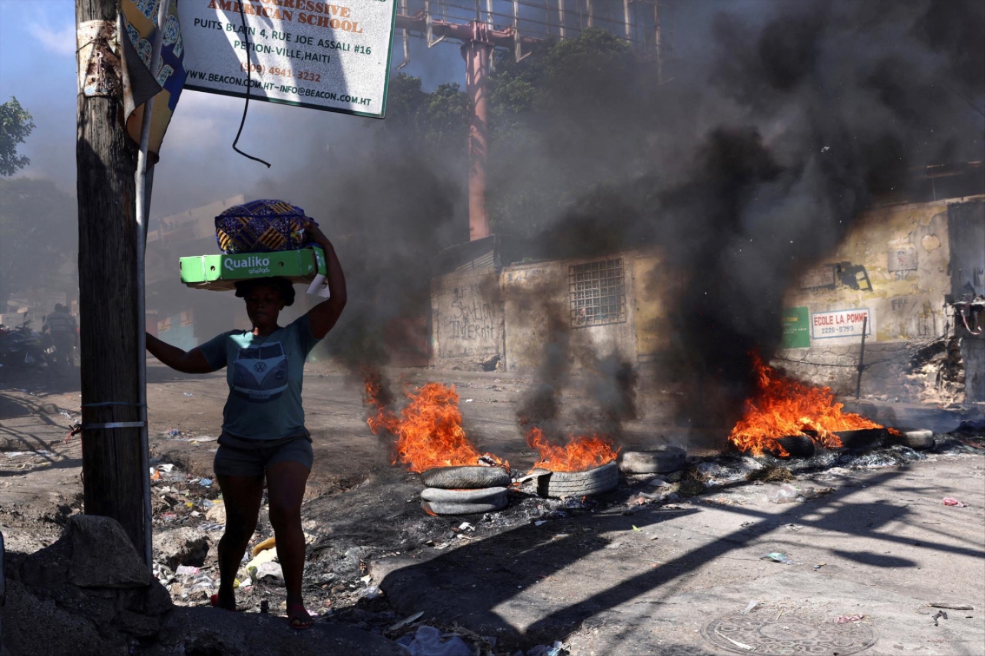 A woman walks past a burning barricade set during a protest against insecurity, in the Petion-Ville neighborhood of Port-au-Prince, Haiti April 2, 2025. Ralph Tedy Erol/Reuters