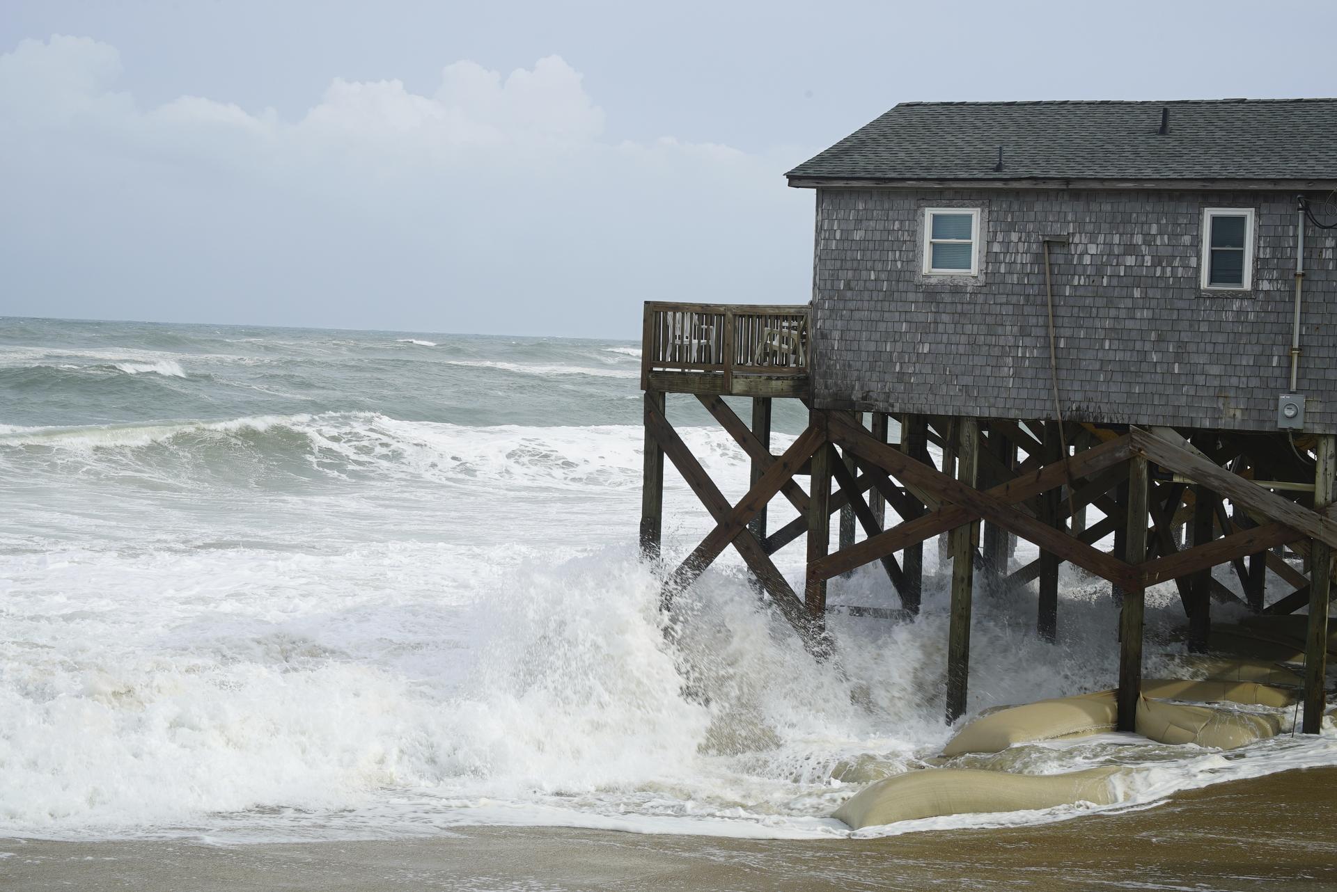 Waves from Hurricane Erin crash against the sandbagged pilings of a building in Buxton, N.C., on Wednesday. 