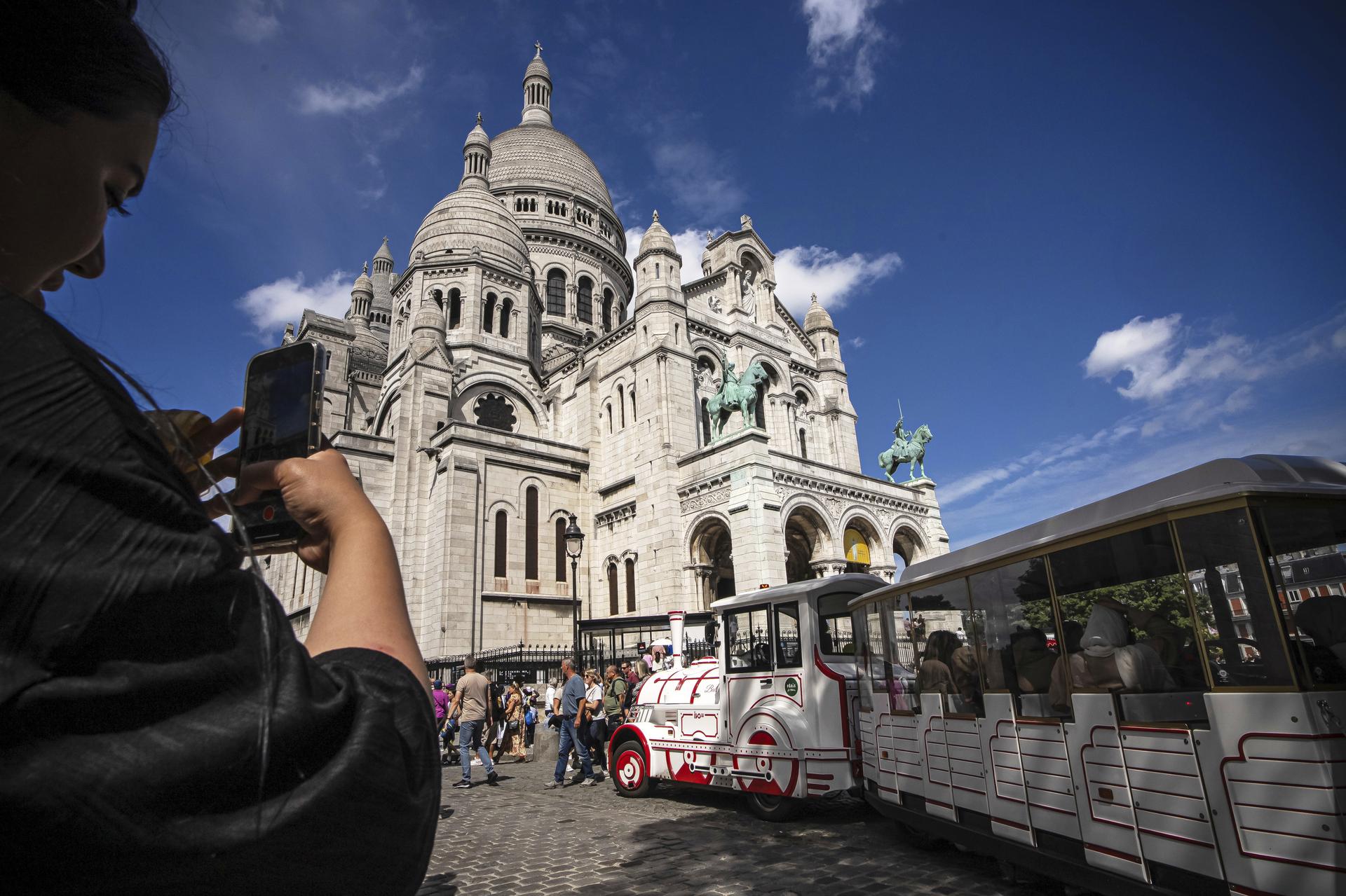 A tourist takes a picture of the Sacre Coeur basilica in the Montmartre district in Paris, France, on Aug. 4. (AP Photo/Aurelien Morissard)