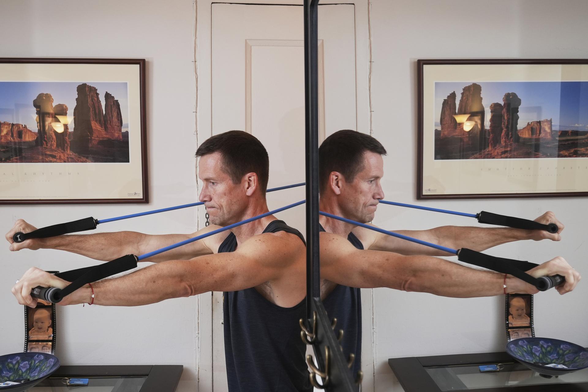 Charles Scott works out with resistance bands at home in New York. 