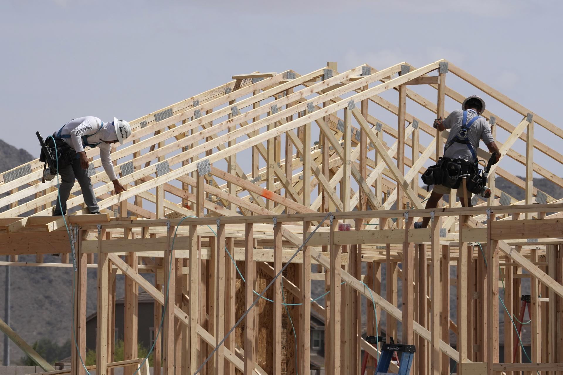 Construction workers frame up a roof at a new home in April in Laveen, Ariz. 