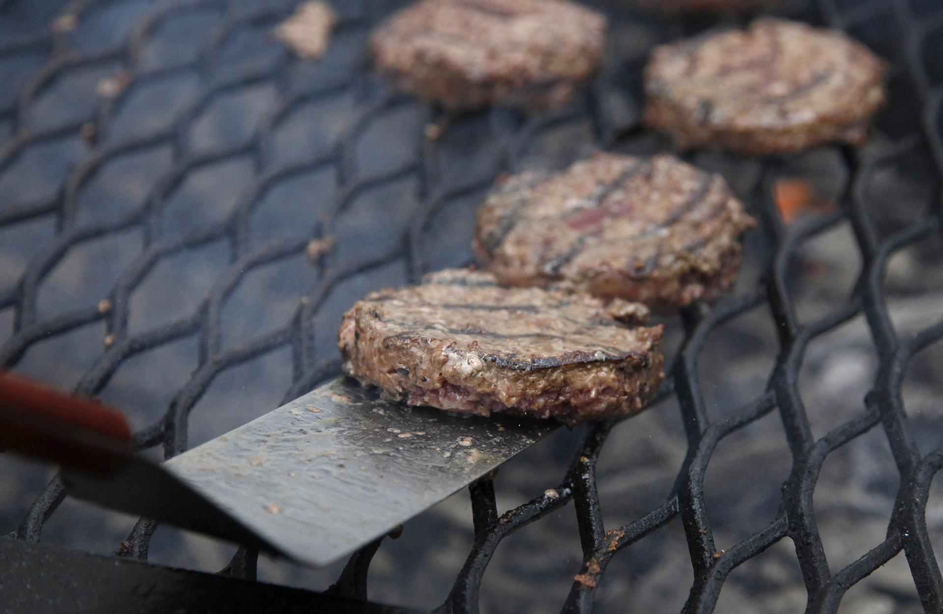 Hamburgers are tended to on a grill in Washington. 