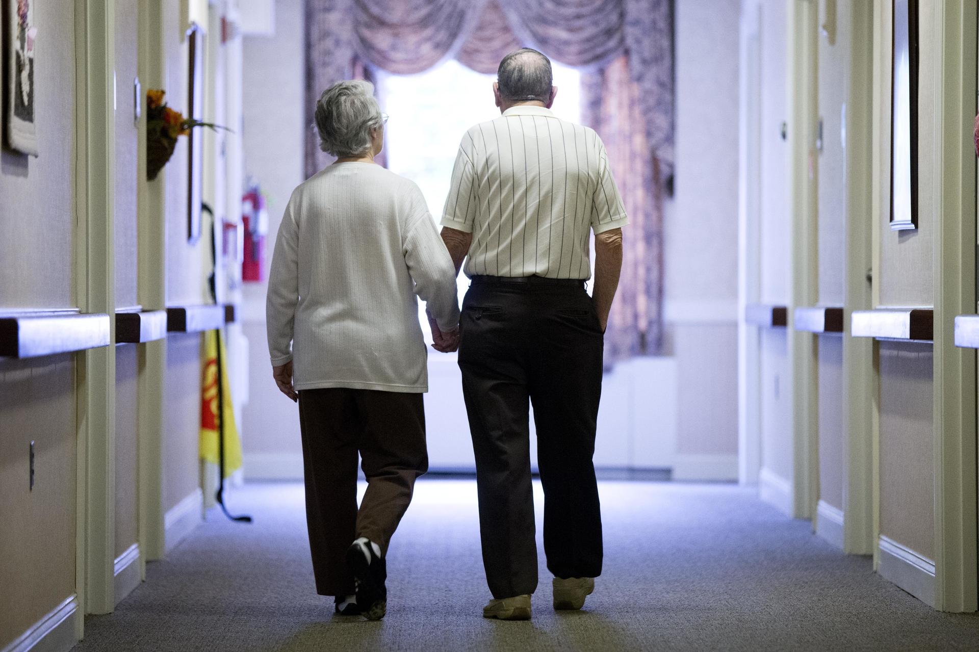 An elderly couple walks down a hallway in Easton, Pa., in 2015. 