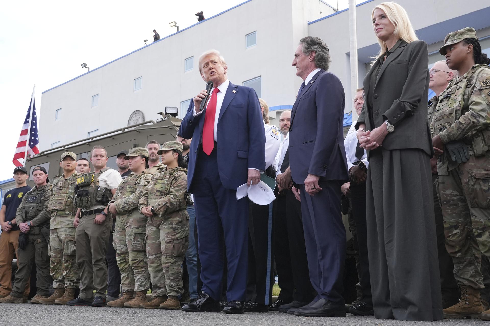 President Donald Trump speaks with members of law enforcement and National Guard soldiers, Thursday, in Washington, as Interior Secretary Doug Burgum and Attorney General Pam Bondi listen.
