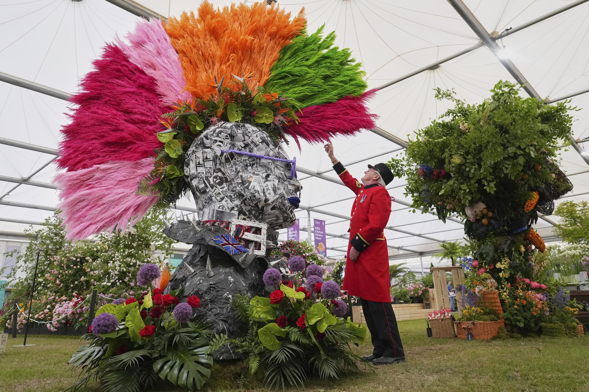Chelsea pensioner Peter Wilson reaches up to touch a punk's mohawk at the RHS Chelsea Flower Show in London.