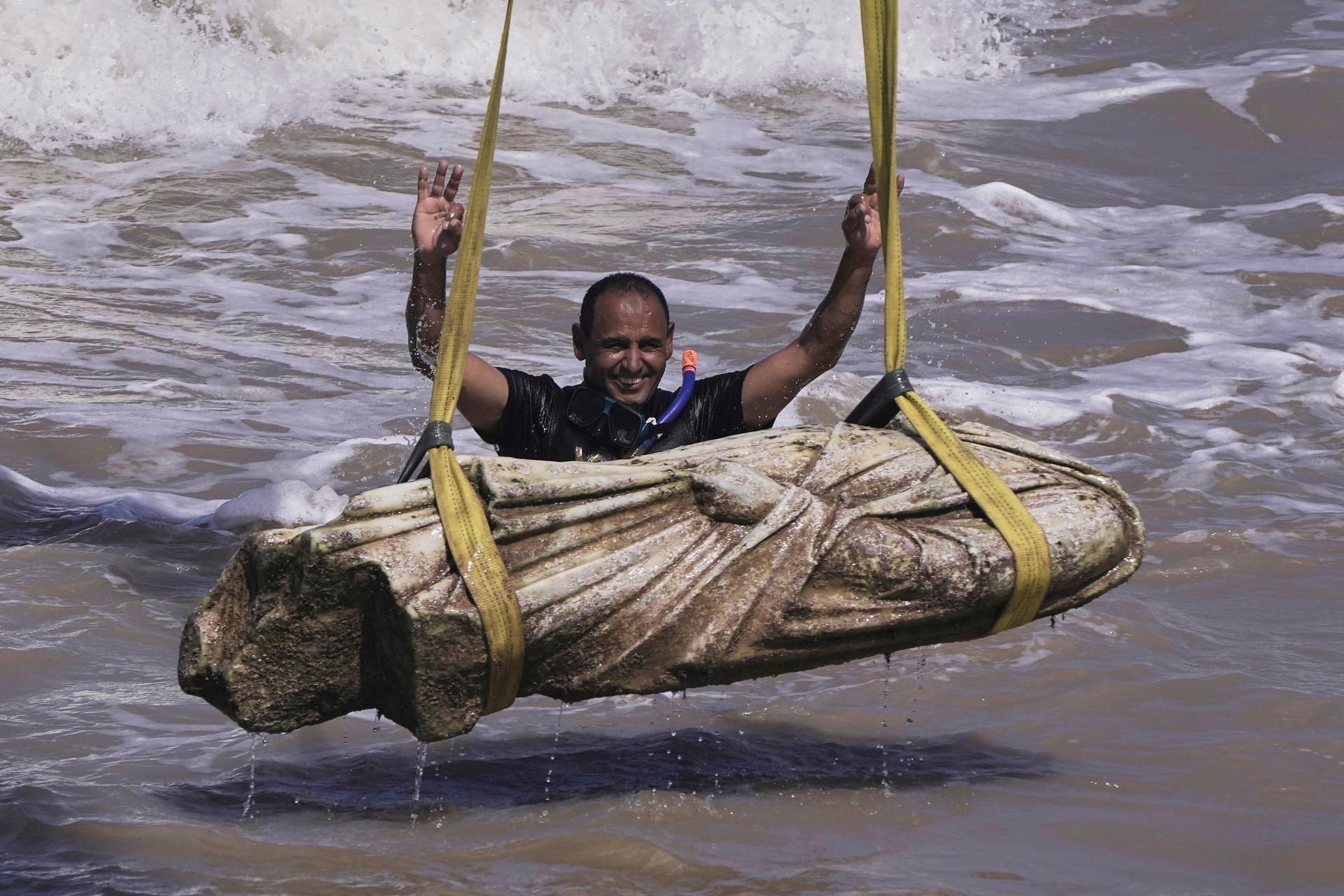 A diver celebrates after an ancient relic was lifted out of the water in the Abu Qir Bay in Alexandria, Egypt.