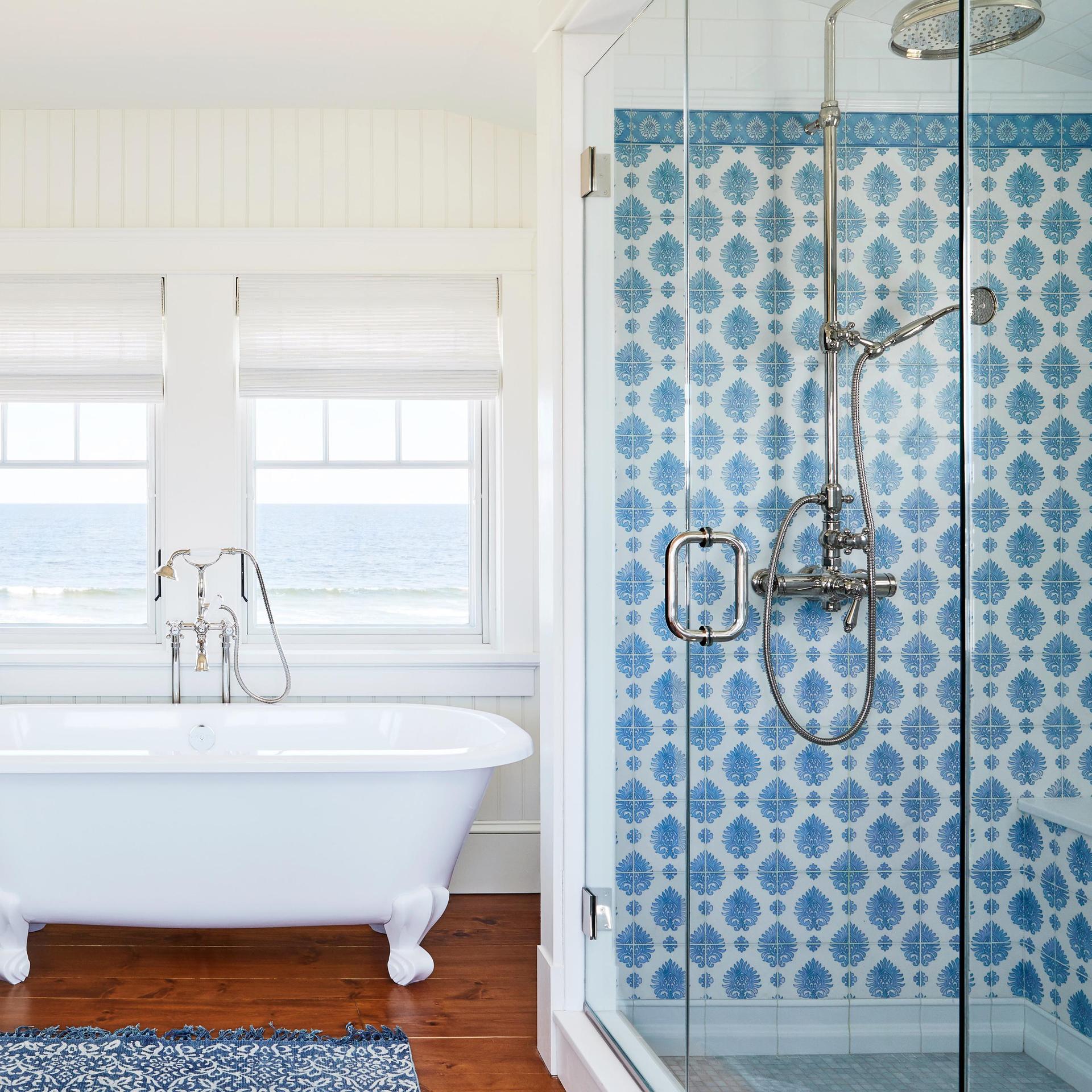 pretty white bathroom with clawfoot tub and blue and white tiled walk in shower