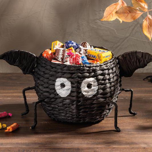 cute black woven basket that looks like a bat filled with halloween candy