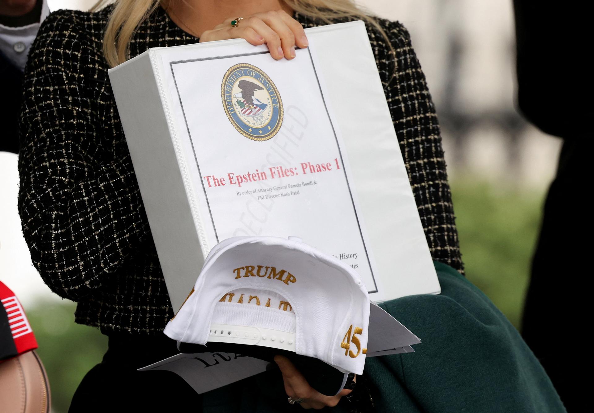 People walk out of the West Wing of the White House with 'The Epstein Files: Phase 1' binders in February