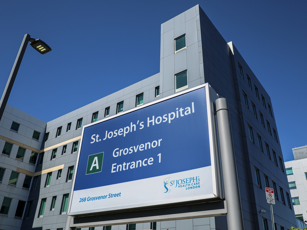 Sign identifying Joseph's Hospital in London, Ont., with hospital towering behind it.