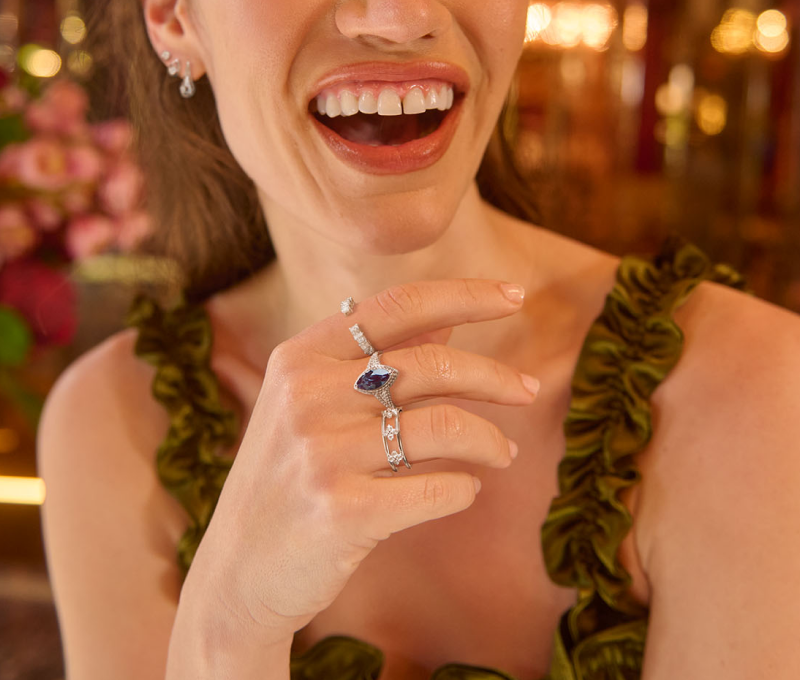Women smiling and sowing beautiful jewelry including rings and earrings.