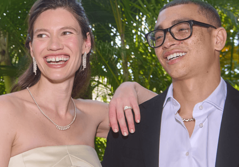 A woman wearing stunning jewelry rests her hand on her partner