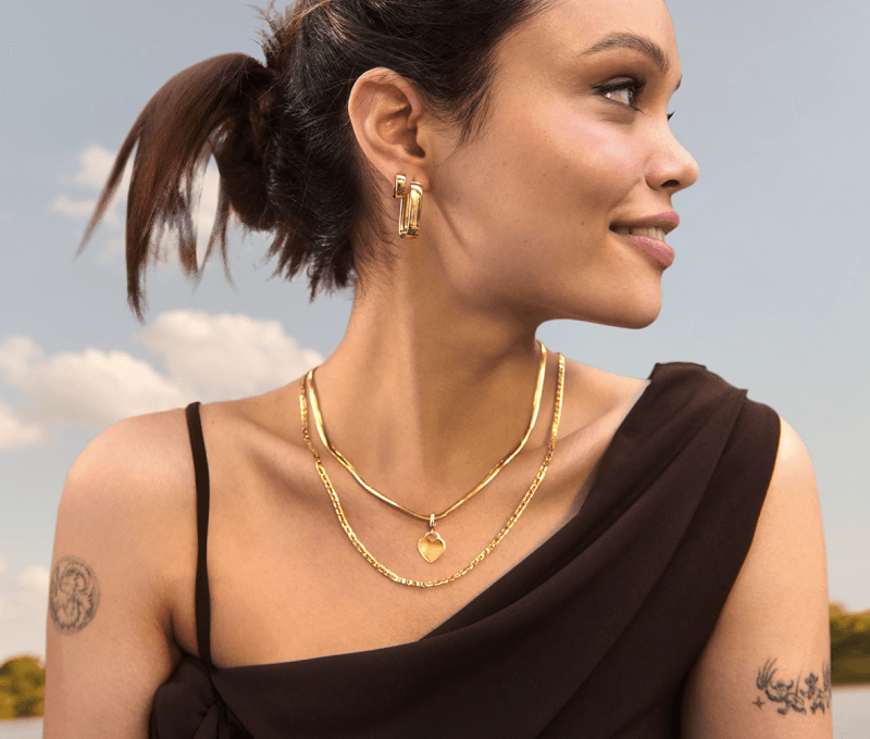 A woman displays stunning gold earrings and necklaces