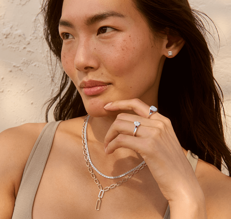 A woman holds her hand up to her chin to reveal stunning rings and necklaces