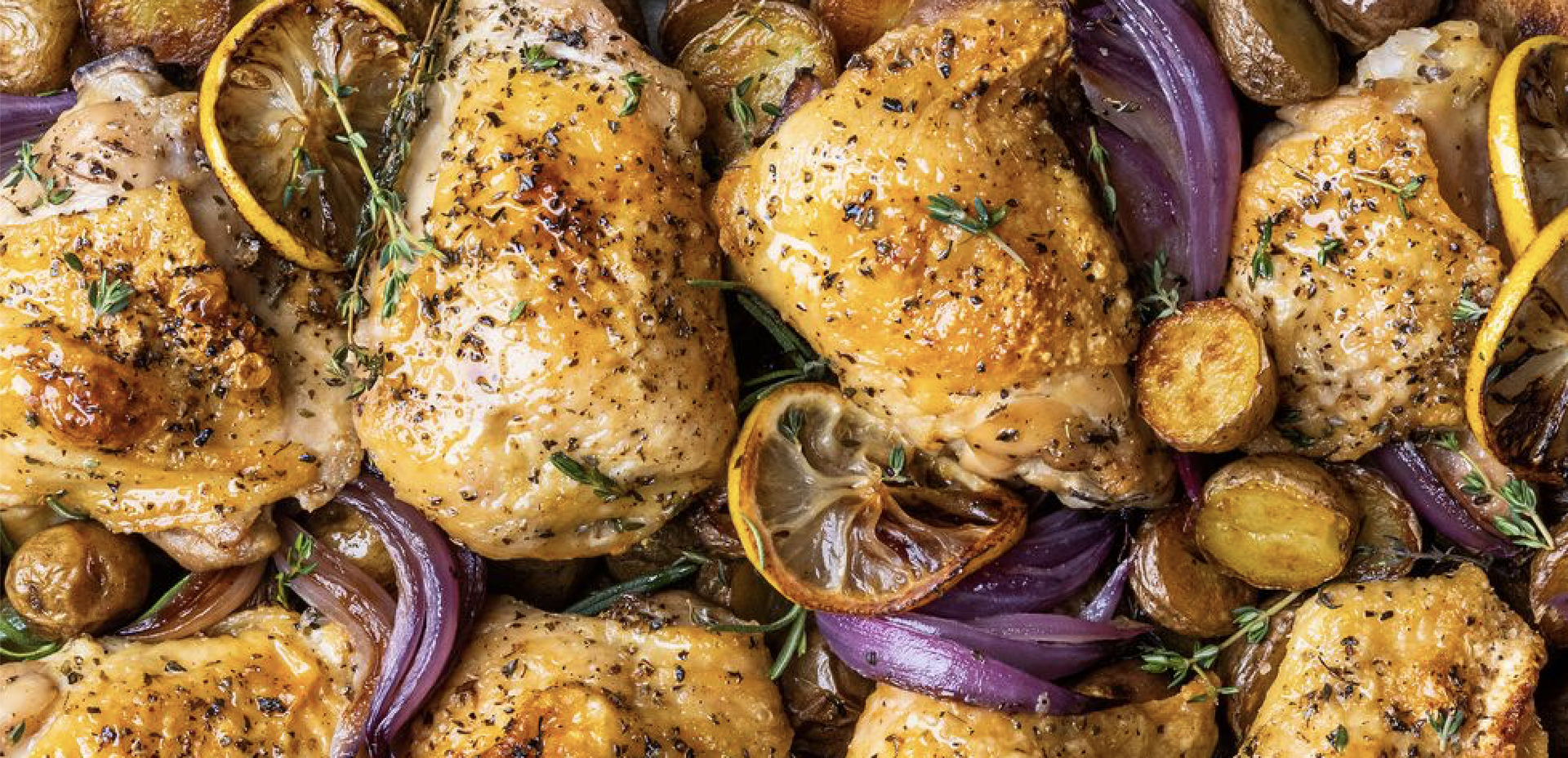 Cooked and seasoned chicken thighs with sliced lemons, potatoes and shallots Cooked and seasoned chicken thighs with sliced lemons, potatoes and shallots