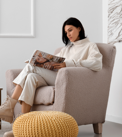 woman sitting in a chair reading a magazine