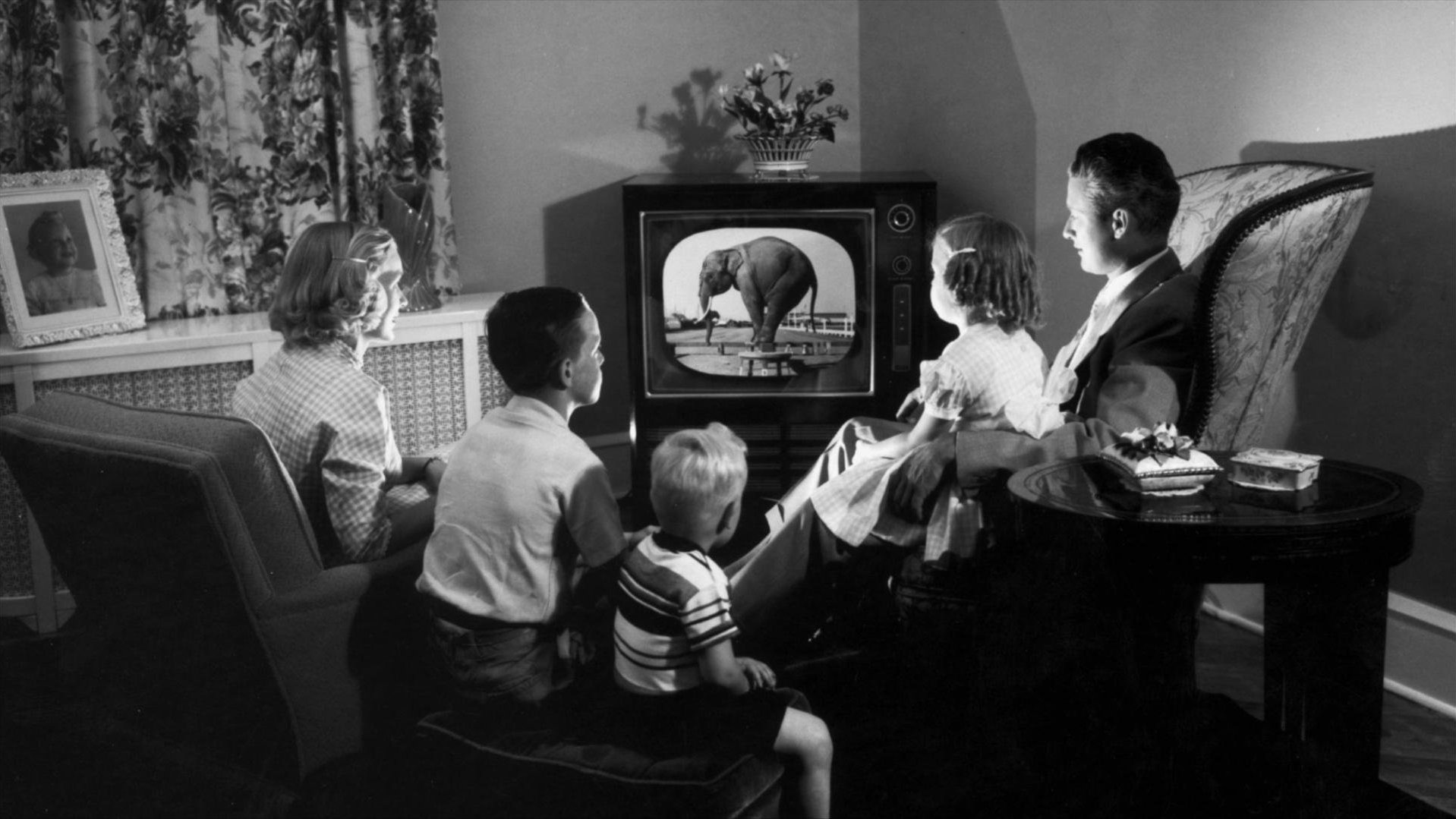 Photo of a family watching TV in the 1950s