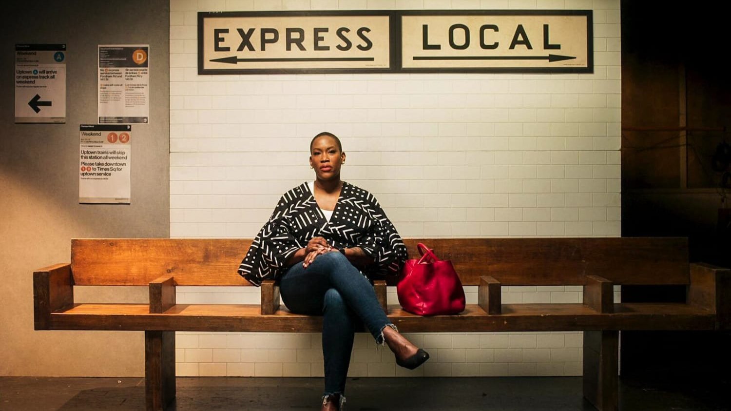 A woman sitting at a train station bench.