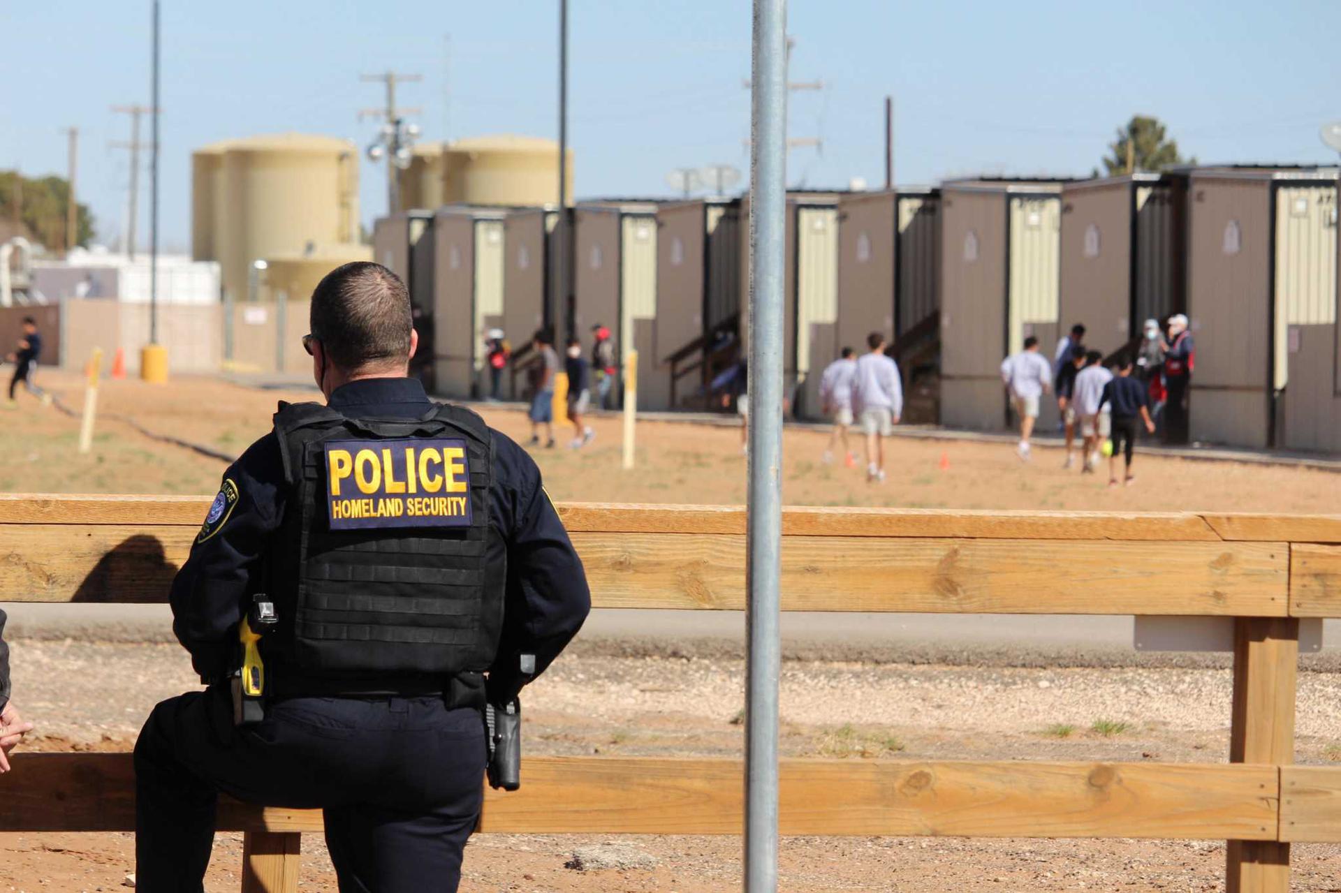 A Department of Homeland Security officer stands outside the facility in Midland County for unaccompanied juvenile migrants who crossed the U.S.-Mexico border