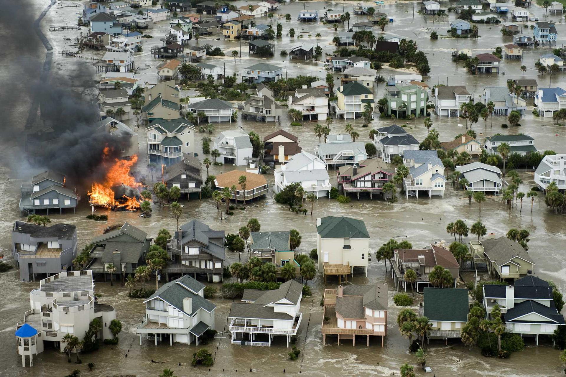 A house is totally engulfed in flames as floodwaters and crashing waves inundated beach homes on Galveston Island as Hurricane Ike approaches the Texas Gulf Coast, Friday, Sept. 12, 2008.