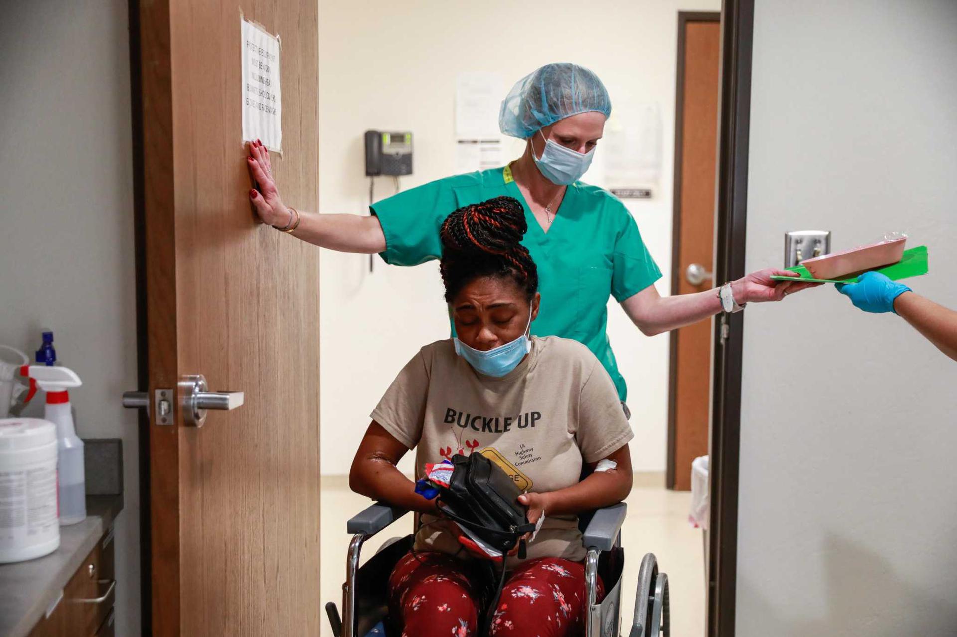 Volunteer Jennifer Goodner (top) helps patient Judith, 33, in a wheelchair after getting a surgical abortion at the Trust Women's clinic on Thursday, Sept. 9, 2021 in Oklahoma City, Oklahoma. Judith had to travel over six hours from Houston, Texas to get the procedure. Judith suffers from Type 1 diabetes and her partner with whom she shares four kids with suffers from kidney failure.