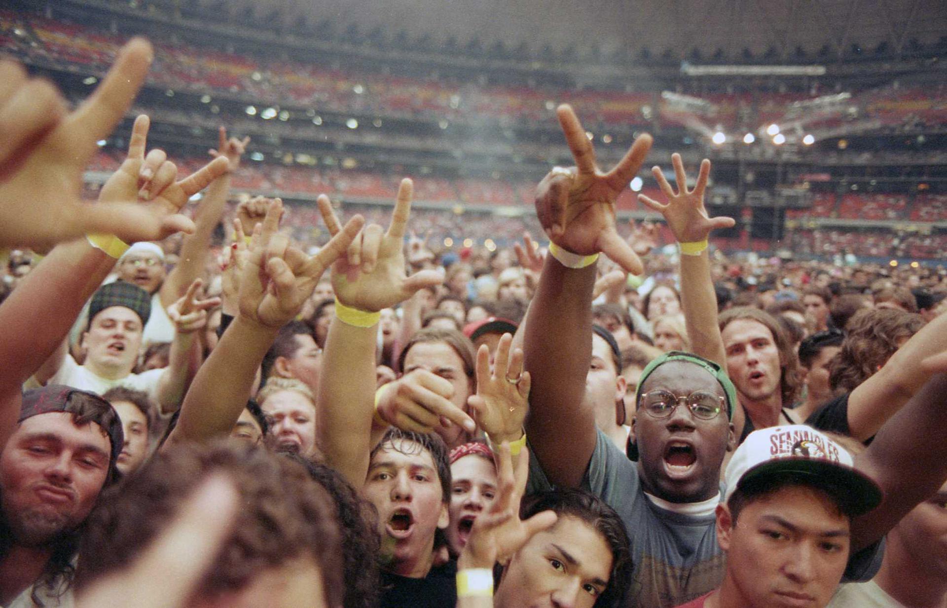 Fans raise their hands at a Metallica concert at the Astrodome.