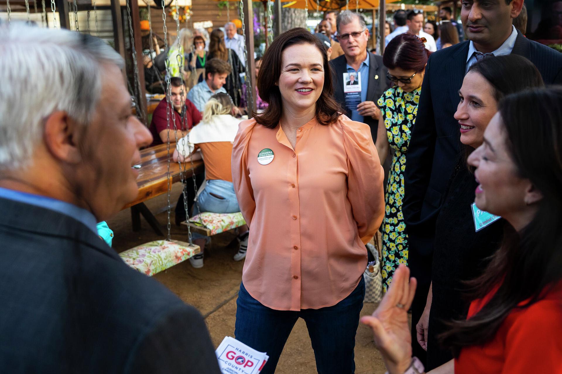 Alexandra del Moral Mealer chats with attendees and other candidates running for different offices during a meet and greet in the Heights.